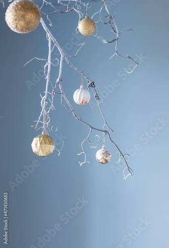 white branch with christmas golden balls on blue background