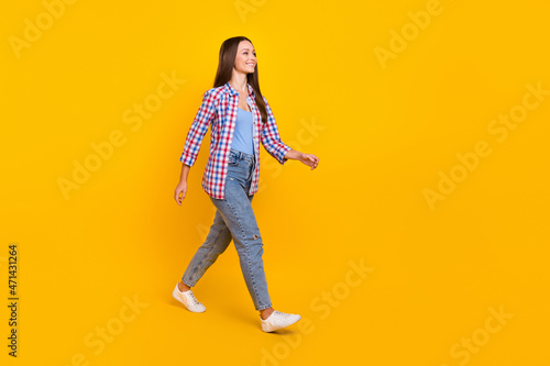 Full length profile photo of lady enjoy weekend promenade wear plaid shirt isolated yellow color background