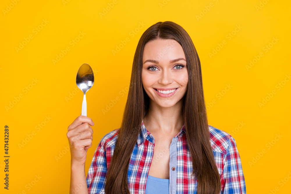 Photo of positive lady hold silver spoon healthy diet promotion wear plaid shirt isolated yellow color background Photo of positive lady hold silver spoon healthy diet promotion wear plaid shirt isolated yellow color background