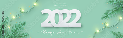 Happy New Year 2022 design. Light green background with paper cuted 2022, realistic pine branches and garland lights. Horizontal poster, greeting card, banner, website header in modern minimal style photo