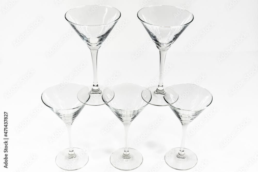 Empty martini cocktail glasses stand on top of each other on white background Empty martini cocktail glasses stand on top of each other on white background