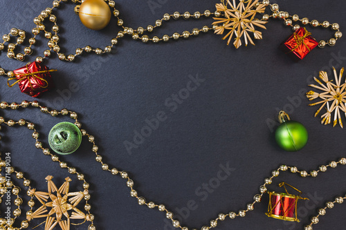 Christmas straw snowflakes, baubles and other decoration on black festive background. Winter holidays concept. Flat lay, top view, copy space