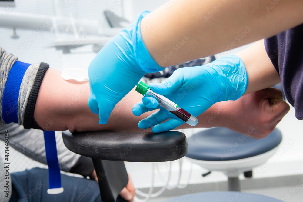 A medical technologist makes a blood collection service for a patient. Close-up