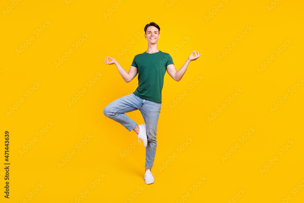 Full body photo of charming positive calm man asana yoga good mood isolated on yellow color background