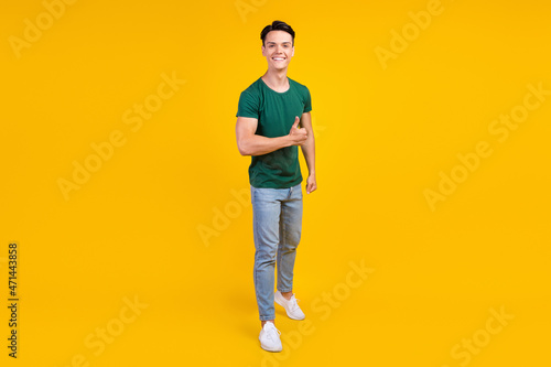 Full body photo of cheerful happy positive man hold hand thumb up smile enjoy isolated on yellow color background