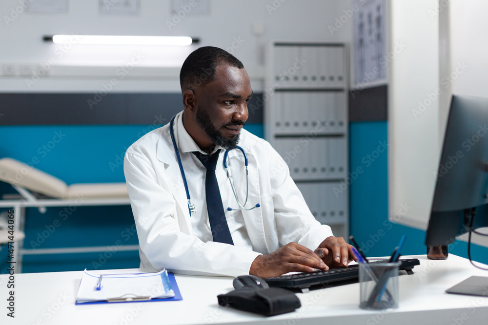 African american therapist doctor typing healthcare treatment on computer after analyzing sickness symptoms expertise during clinical consulation. Therapist working in hospital medical office African american therapist doctor typing healthcare treatment on computer after analyzing sickness symptoms expertise during clinical consulation. Therapist working in hospital medical office
