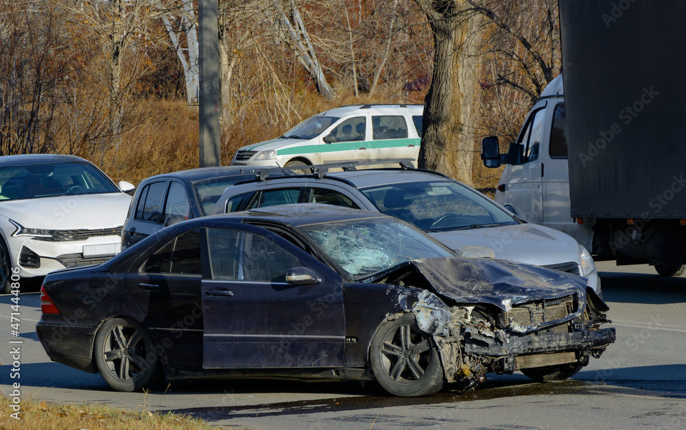 Naklejka premium a black passenger sedan stopped after a serious accident with a broken hood and a broken windshield. fuzzy focus
