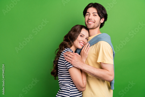 Profile side photo of young couple happy positive smile hug embrace trust suppport isolated over green color background © deagreez