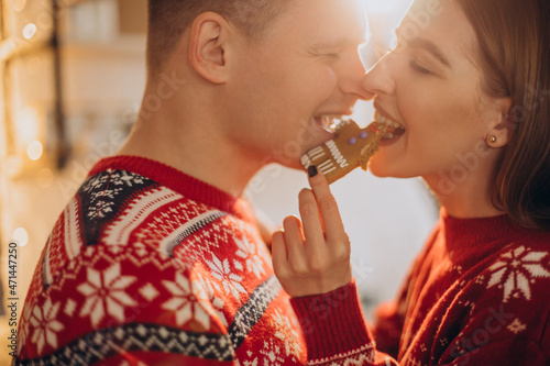 Couple at kitchen eating christmas cookie man