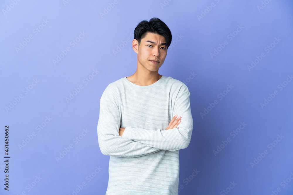 Young Chinese man isolated on purple background feeling upset Young Chinese man isolated on purple background feeling upset