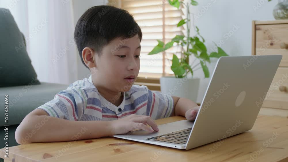 Asian little boy using laptop at home morning, asia child learn online Asian little boy using laptop at home morning, asia child learn online