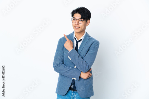 Young Chinese business man isolated on white background pointing to the side to present a product