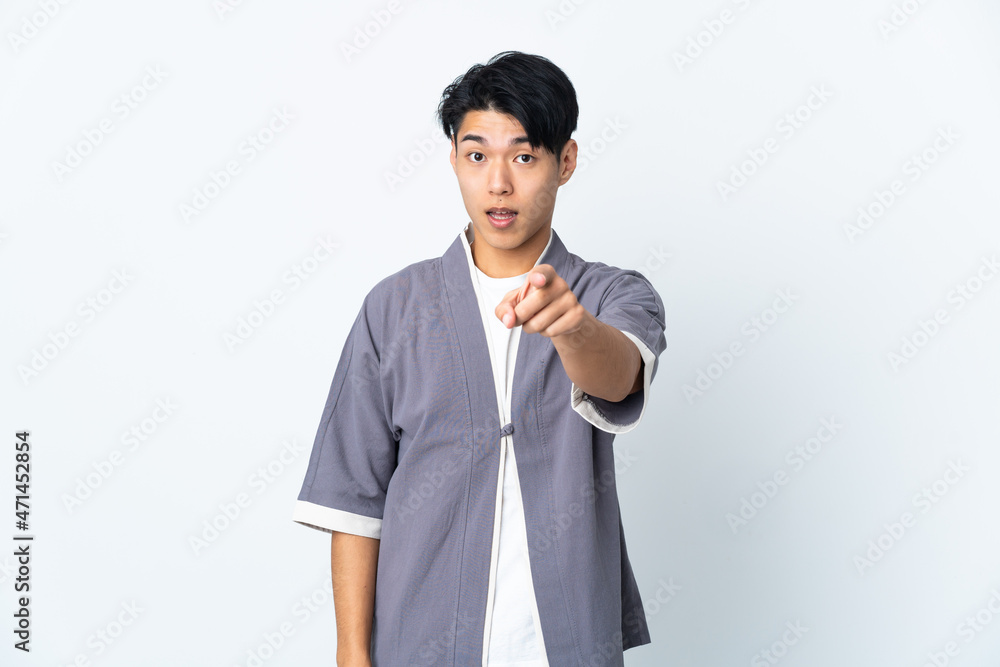 Young Chinese man isolated on white background surprised and pointing front Young Chinese man isolated on white background surprised and pointing front