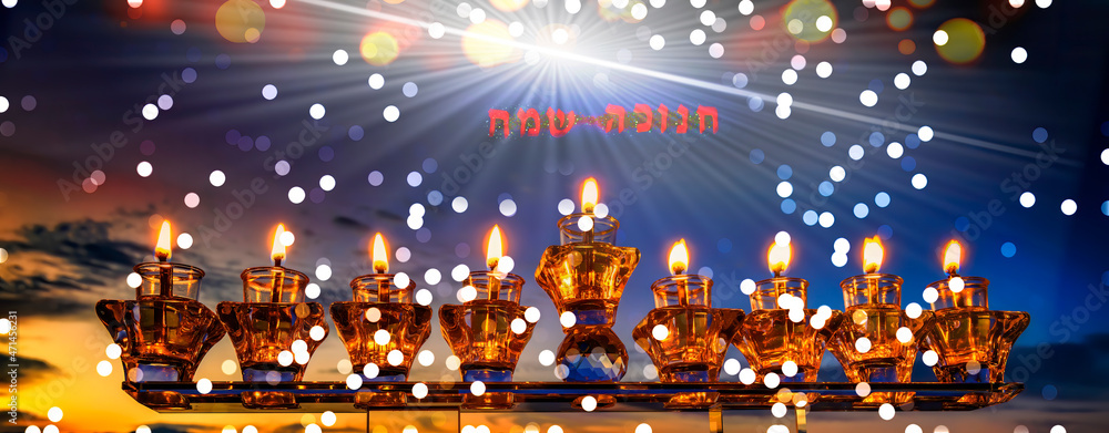 Low key image of Jewish holiday of light – Hanukkah, Hebrew letters that mean - Happy Hanukkah, selected focus on crystal menorah with olive oil burning candles, digitally generated bokeh and sunbeam 