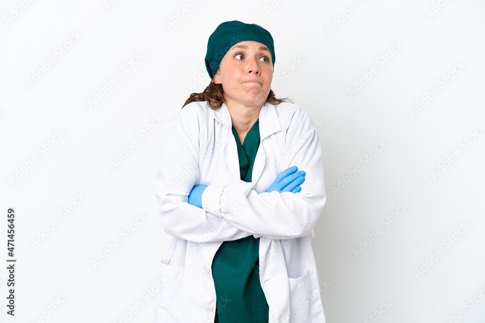 Surgeon caucasian woman in green uniform isolated on white background making doubts gesture while lifting the shoulders Surgeon caucasian woman in green uniform isolated on white background making doubts gesture while lifting the shoulders