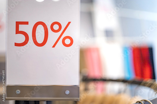 Closeup advertising board with 50 percent discount inscription at fashion clothes boutique
