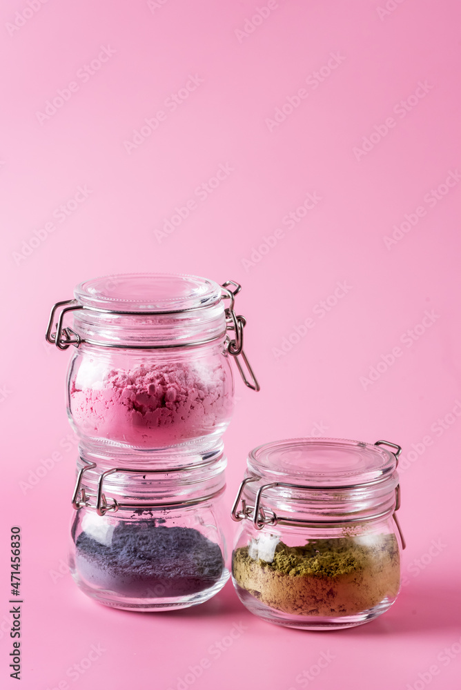 Different of japanese matcha tea green red and blue in glass jars on Pink Background Acai Berry Powder green tea leaf powder clitoria flower powder vertical Different of japanese matcha tea green red and blue in glass jars on Pink Background Acai Berry Powder green tea leaf powder clitoria flower powder vertical