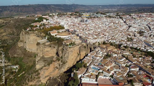Aerial drone footage of the Ronda old town with its famous bridge, the Puente Nuevo or New bridge, in Andalusia, Spain. Shot with a forward and tilt down motion. 