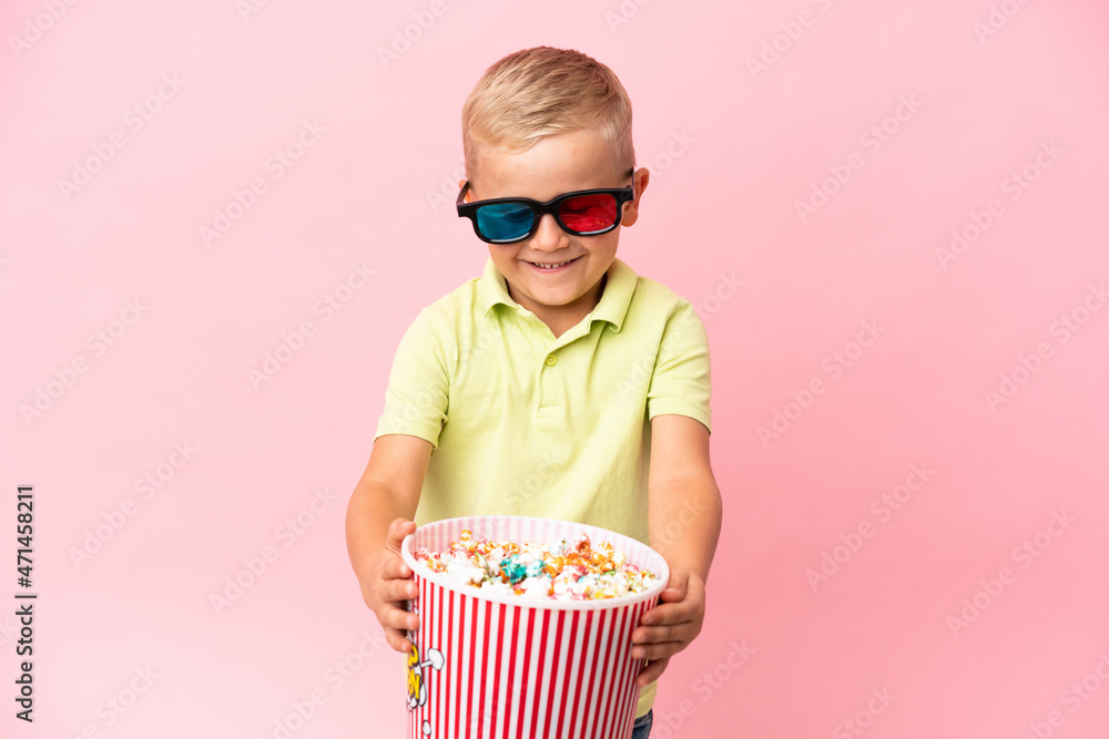 Obraz premium Little Russian boy eating popcorns in a big bowl over isolated background