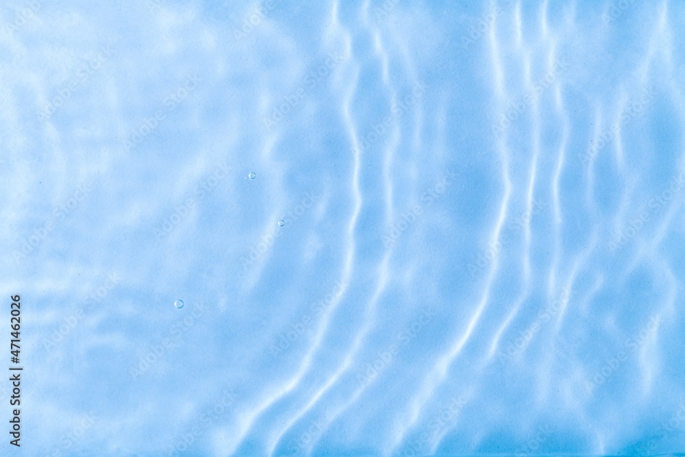 Blurred blue clear calm water surface texture with splashes and bubbles. abstract nature background. Water waves.