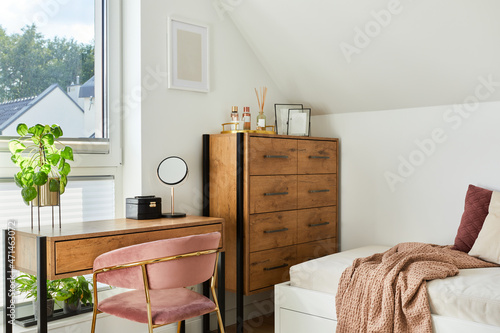 Modern teenage room interior design with bed, table, chest of drawers, pink velvet chair and personal accessories. Template. photo