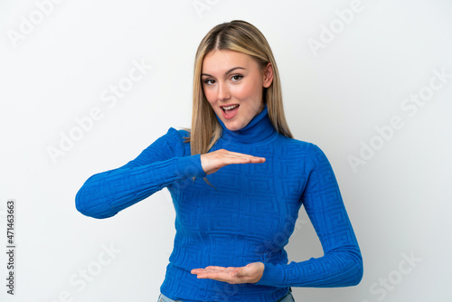 Young caucasian woman isolated on white background holding copyspace imaginary on the palm to insert an ad