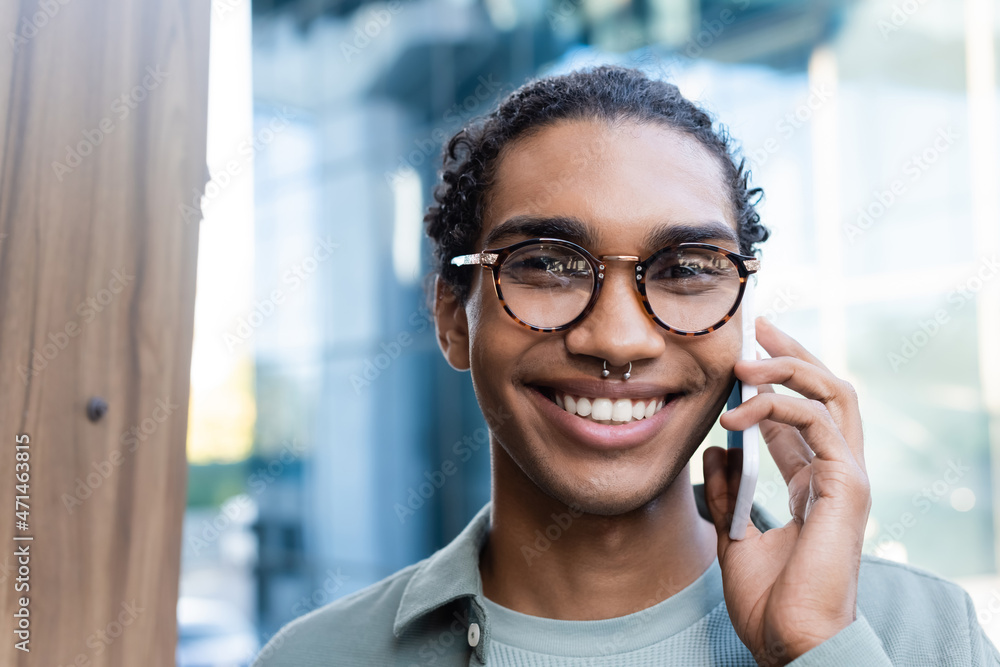 portrait of african american man in eyeglasses calling on cellphone while looking at camera portrait of african american man in eyeglasses calling on cellphone while looking at camera