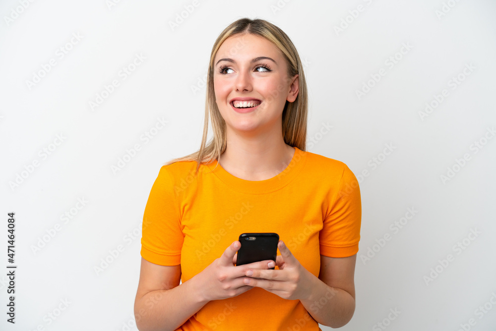 Young caucasian woman isolated on white background using mobile phone and looking up Young caucasian woman isolated on white background using mobile phone and looking up