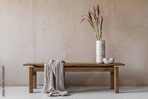 Creative composition with elegant wooden bench. Beautiful decorations and accessories. Modern home interior design. Retro inspiration. Copy space. Structure wall. Template. photo