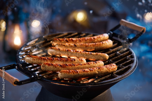 Grilled sausages on grate over fire