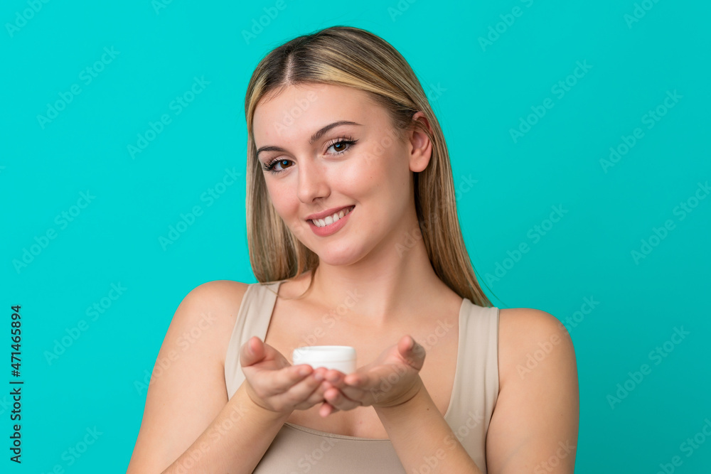 Young caucasian woman isolated on blue background with moisturizer and offering it Young caucasian woman isolated on blue background with moisturizer and offering it