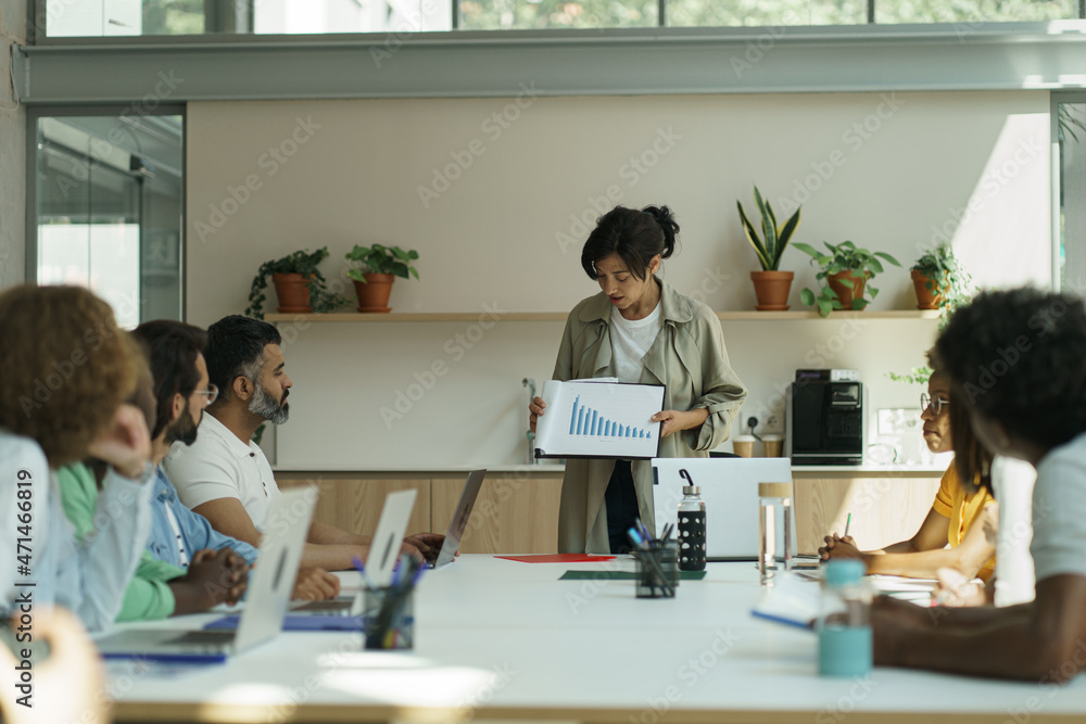 Fototapeta premium Female boss scolding employees for bad work at diverse group meeting, woman executive team leader reprimanding subordinates for bad financial result at company office briefing