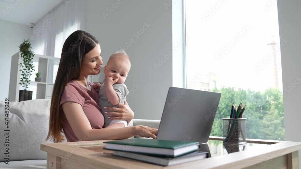 Manager ceo lady sit sofa use netbook maternity leave hold baby indoors Manager ceo lady sit sofa use netbook maternity leave hold baby indoors