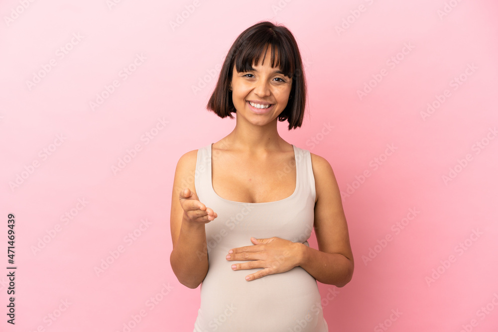 Young pregnant woman over isolated pink background shaking hands for closing a good deal Young pregnant woman over isolated pink background shaking hands for closing a good deal