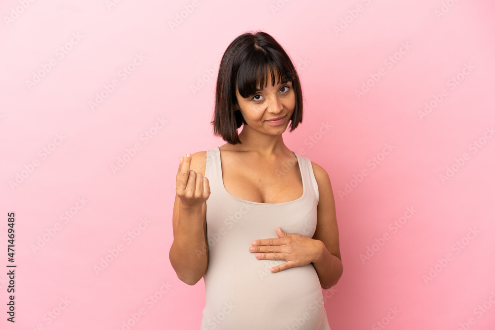 Young pregnant woman over isolated pink background making money gesture Young pregnant woman over isolated pink background making money gesture