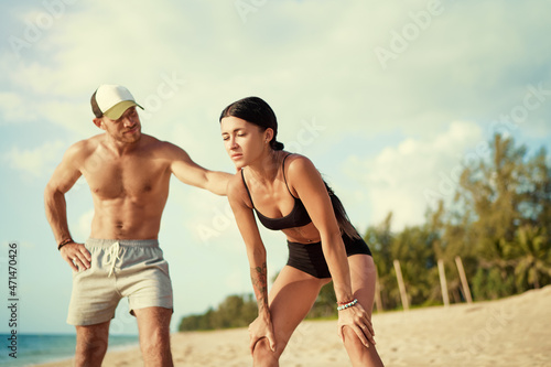 Care and support. Sport lifestyle concept. Young strong man helping his tired girlfriend while jogging