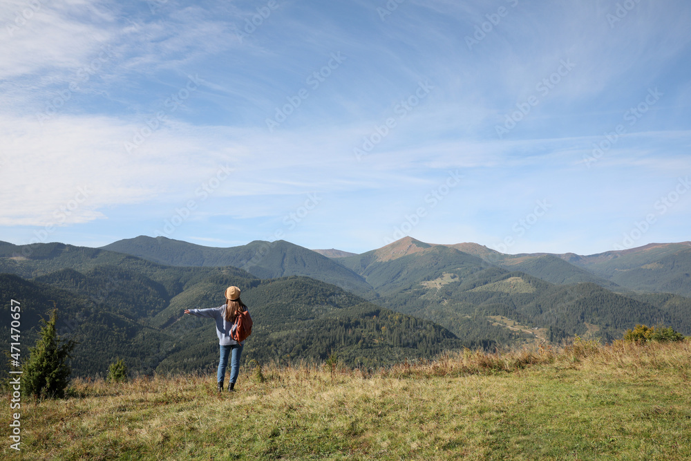Young woman enjoying beautiful mountain landscape, back view