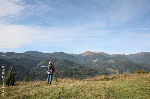 Young woman enjoying beautiful mountain landscape, back view