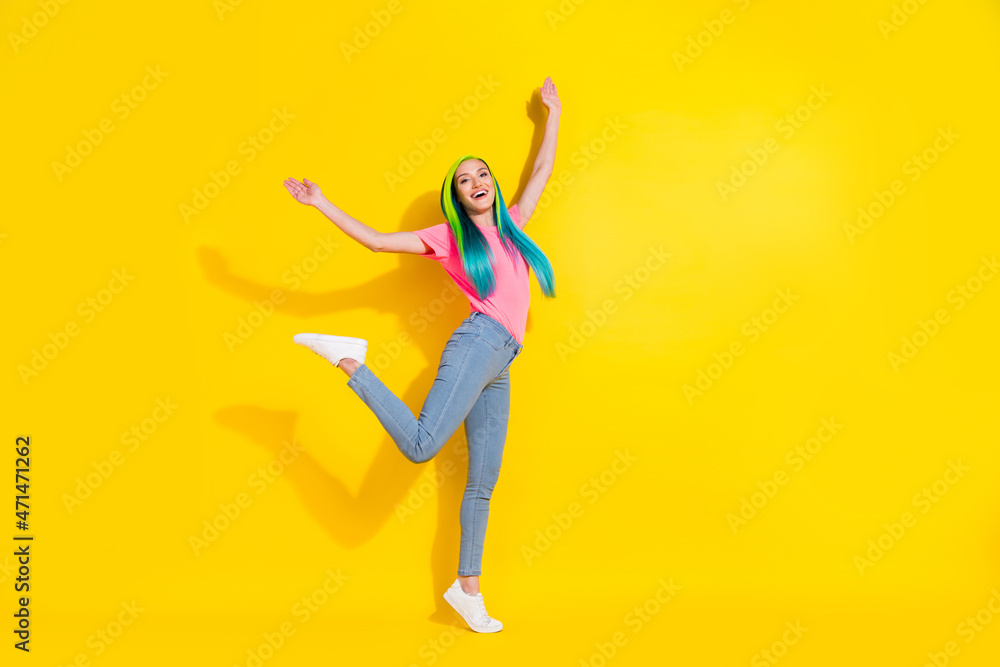 Photo of cheerful positive young bright lady dressed pink t-shirt dancing empty space smiling isolated yellow color background
