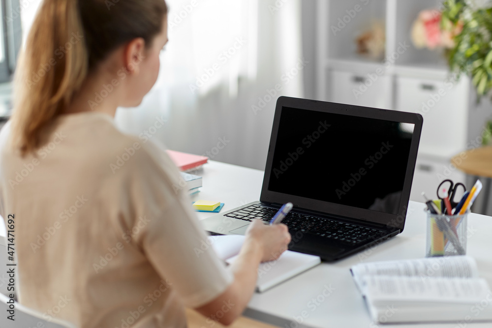 education, online school and distant learning concept - female student woman with laptop computer, notebook and book at home education, online school and distant learning concept - female student woman with laptop computer, notebook and book at home