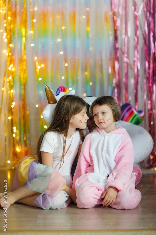 Funny girls children with a unicorn horn in pajamas on a multicolored background, pajama thematic party, children's holidays Funny girls children with a unicorn horn in pajamas on a multicolored background, pajama thematic party, children's holidays