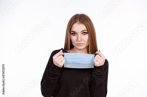 Young girl in a protective mask from the virus on a white background