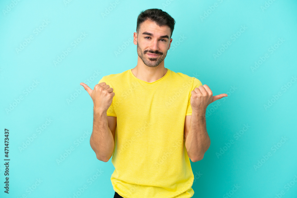 Young caucasian man isolated on blue background with thumbs up gesture and smiling Young caucasian man isolated on blue background with thumbs up gesture and smiling