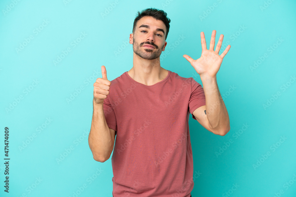 Young caucasian man isolated on blue background counting six with fingers Young caucasian man isolated on blue background counting six with fingers
