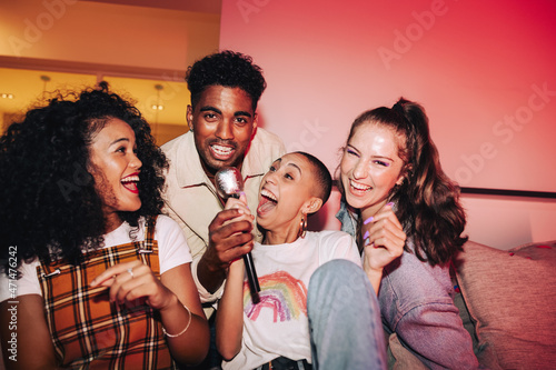 Carefree friends enjoying karaoke night together