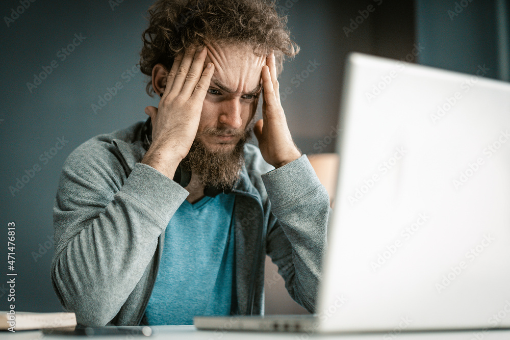 Young Man Looks at the Screen of his Laptop Very Attentively. Remote Work During the Quarantine Period. Online Study. Close-up Portrait Young Man Looks at the Screen of his Laptop Very Attentively. Remote Work During the Quarantine Period. Online Study. Close-up Portrait