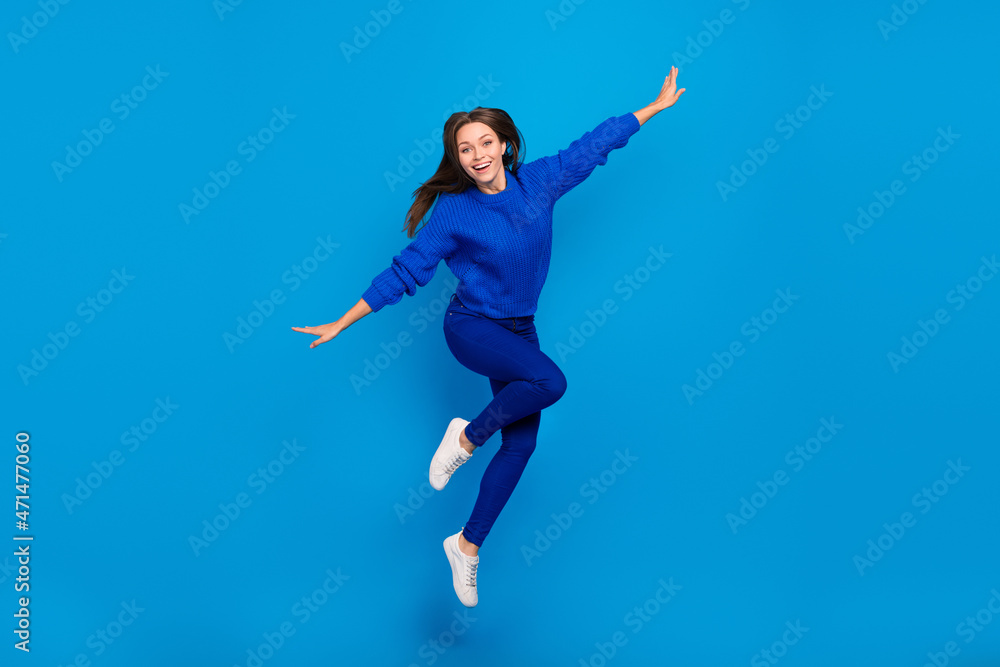 Full length body size view of attractive cheerful carefree girl jumping flying having fun isolated on bright blue color background