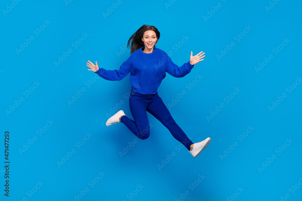 Full length body size view of attractive cheerful funky girl jumping good mood having fun isolated on bright blue color background Full length body size view of attractive cheerful funky girl jumping good mood having fun isolated on bright blue color background