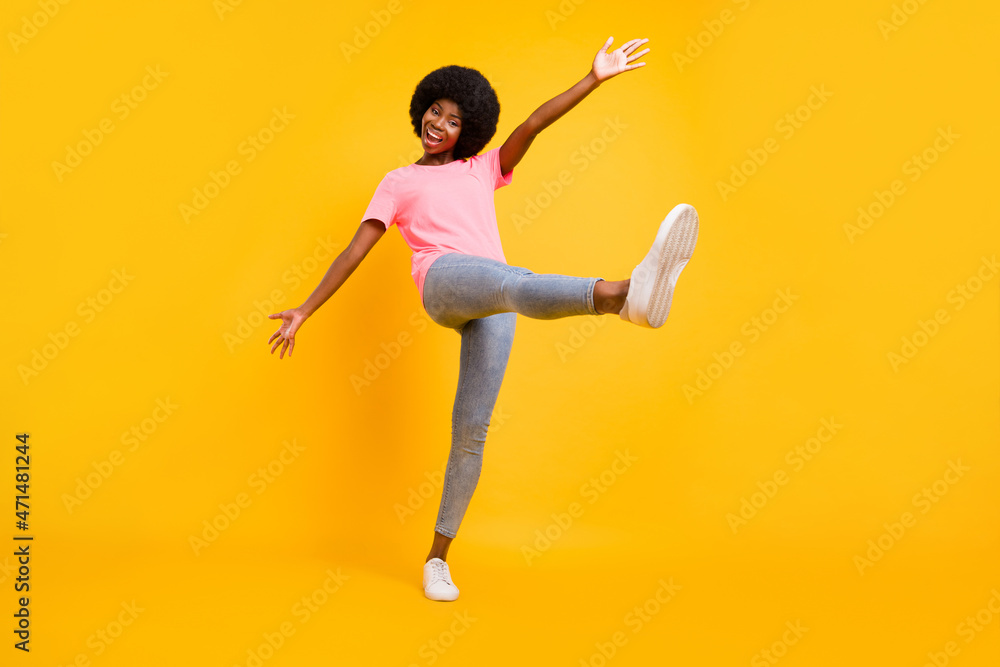 Full body photo of hooray millennial lady dance wear pink t-shirt jeans sneakers isolated on yellow color background