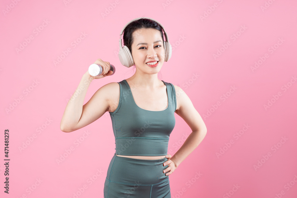 Asian fitness girl portrait, isolated on pink background